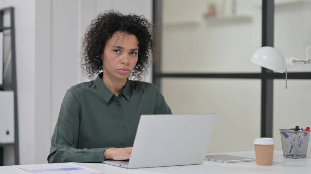 istock African Woman with Laptop Looking at Camera 1347077845