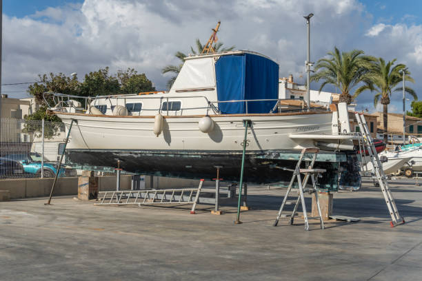 recreational boat supported on metal tripods for future restoration. s'estanyol marina, island of mallorca, spain - industrial ship shipping painting repairing imagens e fotografias de stock