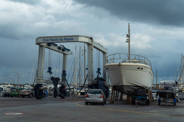 recreational boat supported on metal tripods for future restoration. sa rapita marina, island of mallorca, spain - industrial ship shipping painting repairing imagens e fotografias de stock