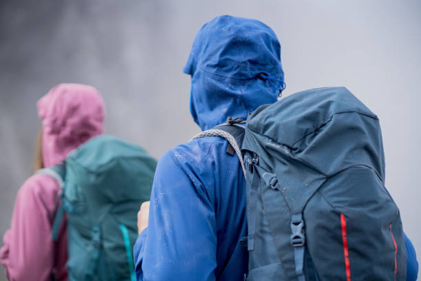 Hiking couple follow footpath through dense fog