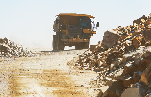 An off highway dump truck hauls fill roil/rock on a road construction site.