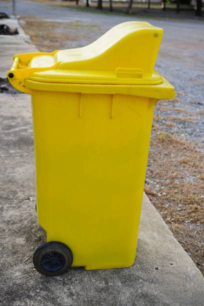 istock Yellow Wheeled Garbage Can  on cement floor 1347083207