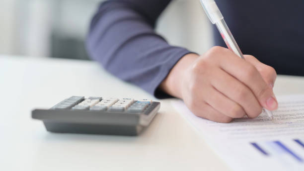 istock Close up of African Woman Writing and Using Calculator 1347084403