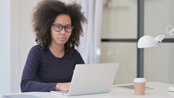 istock African Woman with Laptop Looking at Camera 1347084731