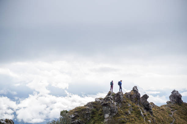 istock Hiking couple relax on grassy mountain peak 1347085926