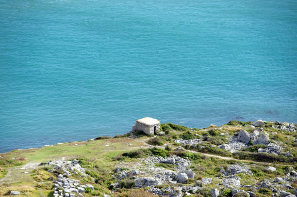 Old quarry hut and coastline, Isle of Portland, Dorset, England. Old ruined quarry hut and coastline quarry remains. The Isle of Portland, is a tied island made of the famous Portland Stone in the English Channel. Portland Bill at the southern tip lies south of Weymouth and is the southernmost point of the county of Dorset, England. Chesil Beach a geological shingle barrier beach joins it to the mainland bill of portland stock pictures, royalty-free photos & images