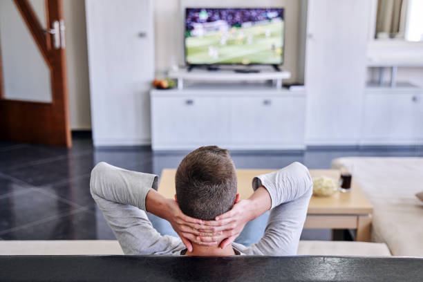 istock Young man watching soccer match at home 1347086903