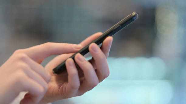 istock Side View of Female Hands Typing on Smartphone 1347088460