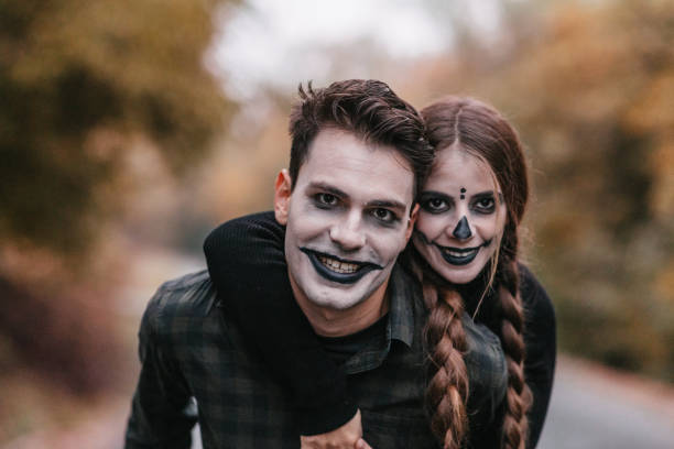Disguised man carrying woman on a piggyback and smiling