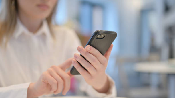 istock Close up of Female Browsing Smartphone 1347088758