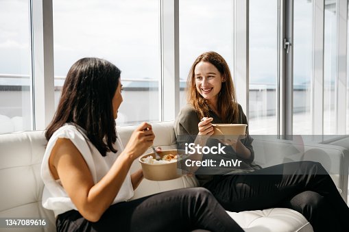 istock Two business women eating healthy lunch at work 1347089616
