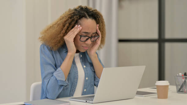 istock African Woman with Headache Working on Laptop 1347090102