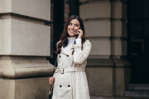 istock Beautiful young woman using a smartphone while out in the city 1347095759