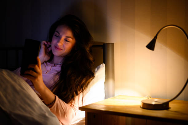 istock Woman lying in her bed during night and using a smartphone 1347095790