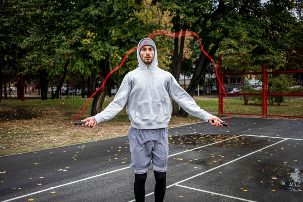 istock Young man with jumping rope on an autumn day training 1347097799