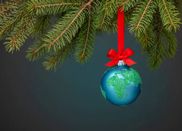 Photo of Peace on Earth Globe christmas ball ornament hanging from a branch.