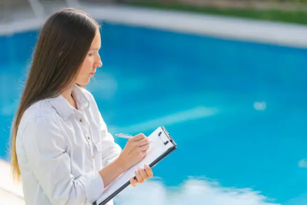 Photo of Female worker checking quality of swimming pool