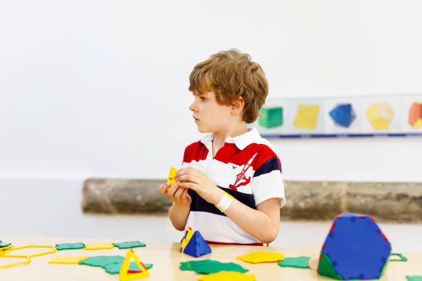 istock Happy kid boy having fun with building and creating geometric figures, learning mathematics and geometry 1347100901