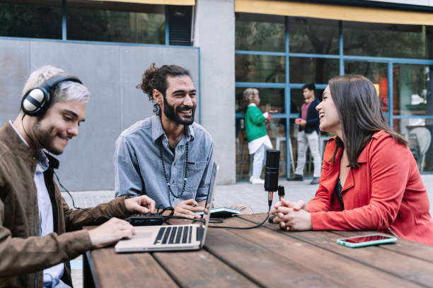 Young content creator journalist recording informal interview conversation with modern woman. Trendy millennial people making podcast for online social media radio networks. Focus on bearded man