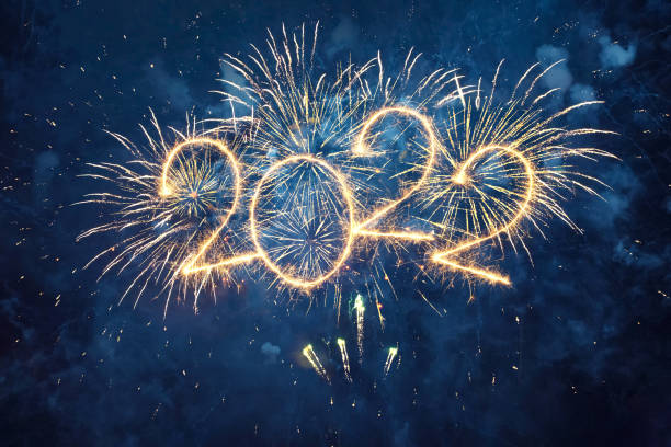 Happy New Year 2022 Happy New Year 2022. Beautiful creative holiday web banner or flyer with Golden firework and sparkling number 2022 on night blue sky background. new year stock pictures, royalty-free photos & images