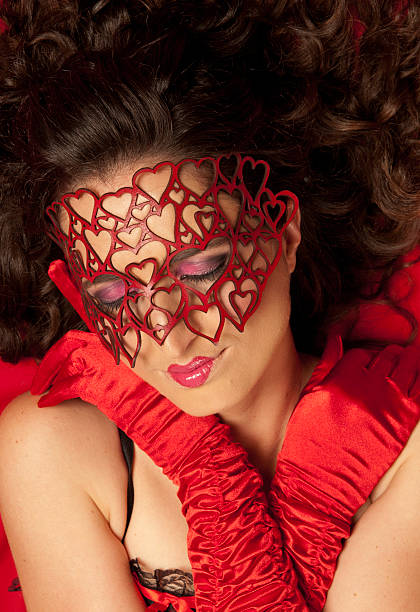 Young, beautiful Caucasian woman wearing red heart mask stock photo