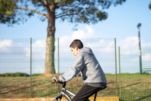 латинский мальчик-подросток с темными волосами едет на велосипеде - bmx cycling sport teenagers only teenager стоковые фото и изображения