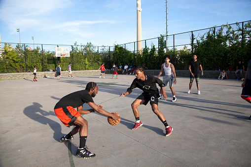 Bronx, New York, USA - June 9, 2019: African American men play basketball in park.