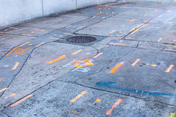 istock Heavily weathered sidewalk with spray painted indicators of buried utility features, manhole cover 1347110455