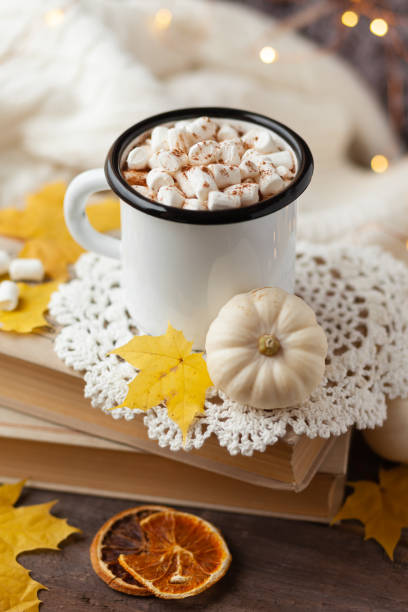 istock Autumn composition with hot chocolate with marshmallow. Aromatherapy on a grey fall morning, atmosphere of cosiness and relax. Wooden background, window sill, close up 1347112711