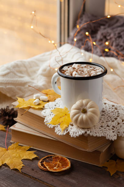 istock Autumn composition with hot chocolate with marshmallow. Aromatherapy on a grey fall morning, atmosphere of cosiness and relax. Wooden background, window sill, close up 1347112728