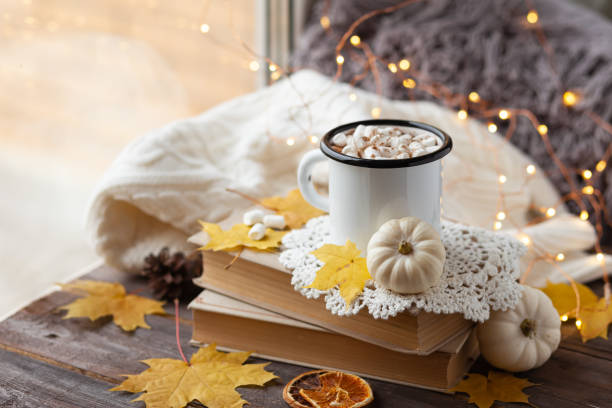 istock Autumn composition with hot chocolate with marshmallow. Aromatherapy on a grey fall morning, atmosphere of cosiness and relax. Wooden background, window sill, close up 1347112729