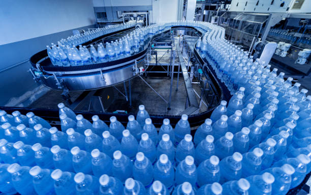 cinta transportadora con botellas de agua potable en una moderna planta de bebidas. - food and drink industry fotografías e imágenes de stock