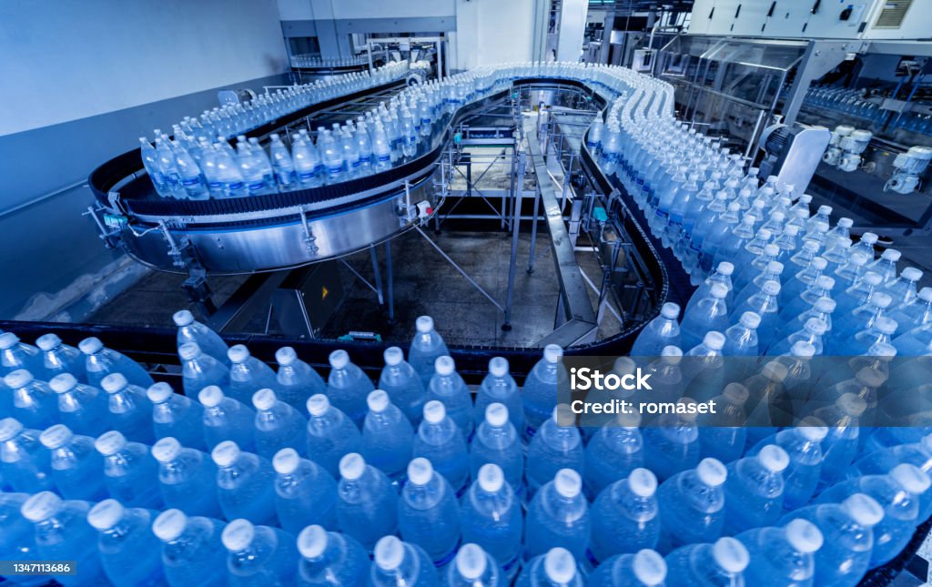 Conveyor belt with bottles of drinking water at a modern beverage plant. Conveyor belt with bottles of drinking water at a modern beverage plant Conveyor Belt Stock Photo