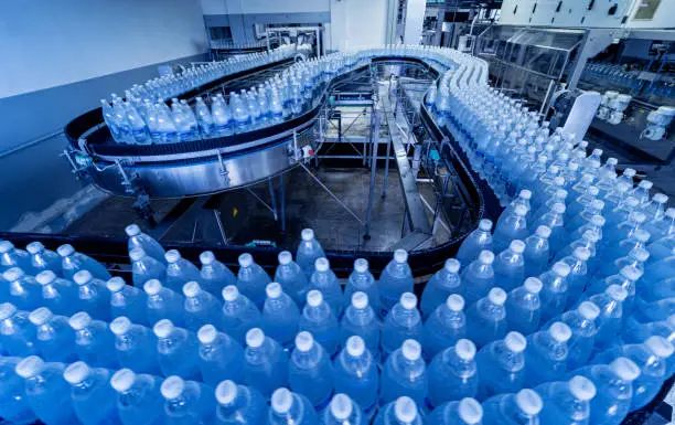 Conveyor belt with bottles of drinking water at a modern beverage plant