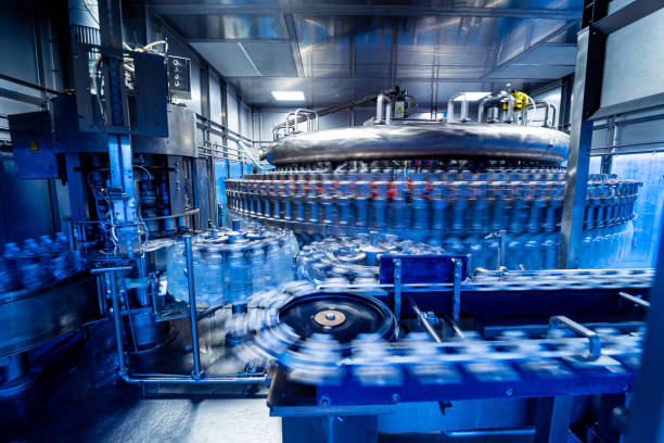 istock Automatic filling machine pours water into plastic PET bottles at modern beverage plant. 1347113748