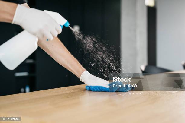 Closeup Of Disinfecting A Wooden Desk To Limit The Spread Of Covid19 Stock Photo - Download Image Now