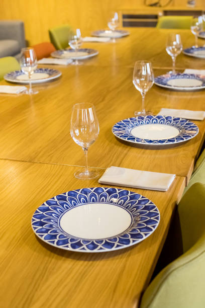 istock Glasses, forks, knives, plates on a table in restaurant served for dinner.catering services background with glasses of wine in restaurant.Empty glasses.table setting,restaurant serving, interior. 1347120104