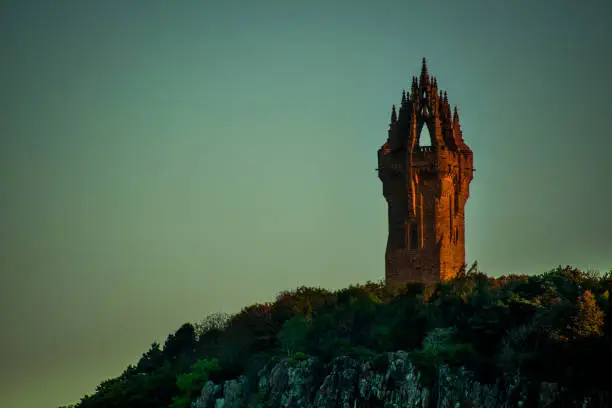 The Wallace monument  in Stirling illuminated by the morning light at sunrise.