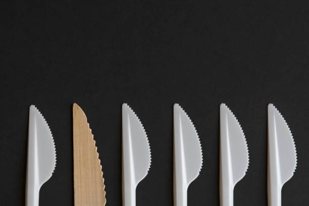 istock Wooden and plastic disposable knifes on black background 1347122765