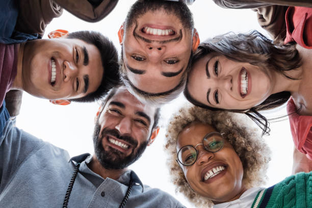 istock Group of diverse friends hugging in circle - Multiracial people team having fun - Focus on african girl face 1347122905