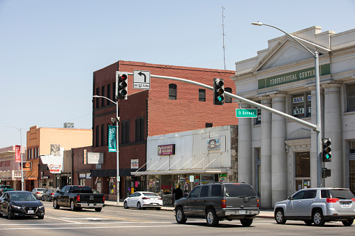 Madera, California, USA - July 15, 2021: Midday traffic passes down east Yosemite Avenue in downtown Madera.