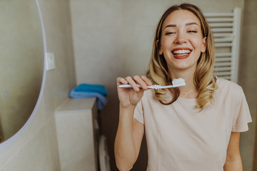 Young woman using her toothbrush