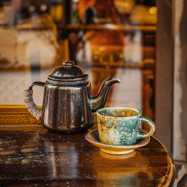 Old Teapot and tea cup closeup on table, low key, vintage background