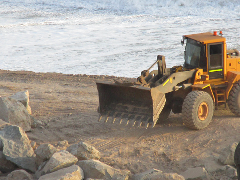 The machine appears in full work about to load rocks.