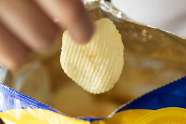 istock Hand hold potato chips with snack bag 1347145537