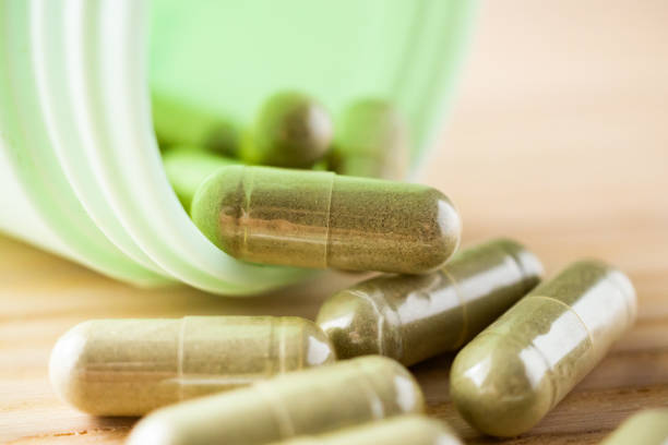 istock Herbal medicine capsules with bottle on wood table 1347145552