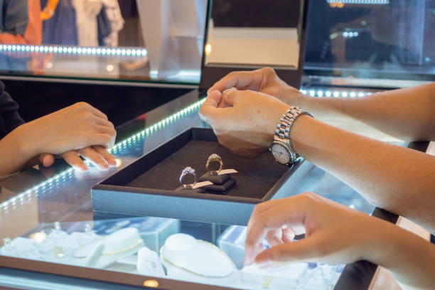kobieta wybierająca pierścionki z brylantami w sklepie jubilerskim - jewelry shopping asian ethnicity luxury zdjęcia i obrazy z banku zdjęć