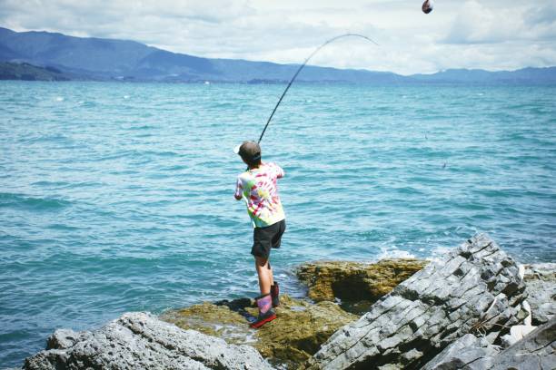 istock Child Fishing on Coastal Rocks 1347146953