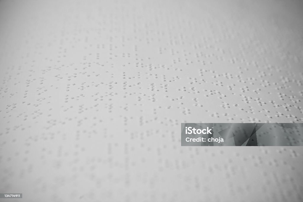 Primer plano de una hoja con señalizaciones en braille en el texto. - Foto de stock de Braille libre de derechos