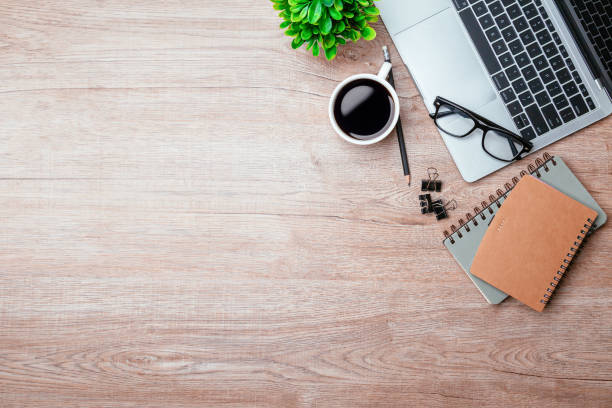 istock Work from home. desk office with laptop, blank notepad, coffee cup and pen on wood table. Flat lay top view copy spce. 1347150278